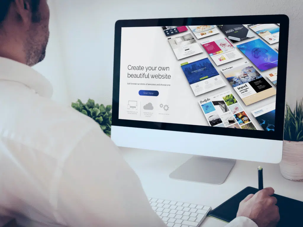 A man sitting at a desk using a computer to create a AI website , with text displayed on the screen.