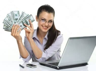 A woman displays cash in front of a laptop, symbolizing success in selling PLR products online.