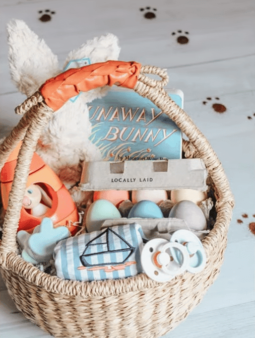 A vibrant baby Easter basket containing an assortment of toys and other playful items.