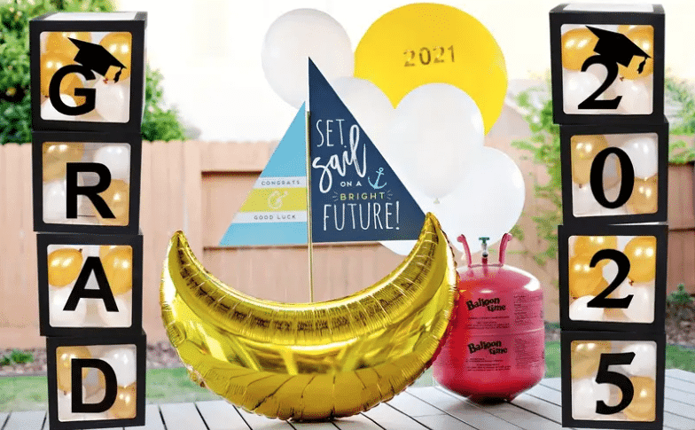 A festive graduation party scene featuring colorful balloons and a celebratory banner amidst a BBQ setup.