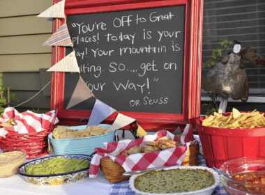 Chalkboard sign reading "You're off to a great day" at a graduation BBQ party, surrounded by festive decorations.