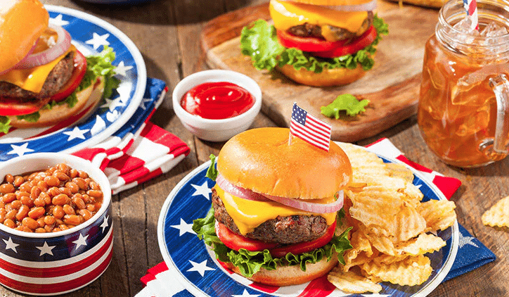 A festive spread of red, white, and blue food and drinks for a graduation BBQ celebration.