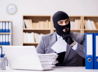 A man wearing a mask sits at a desk, focused on his laptop, with a title reading "The BEST Chat GPT Resume Prompts" nearby.