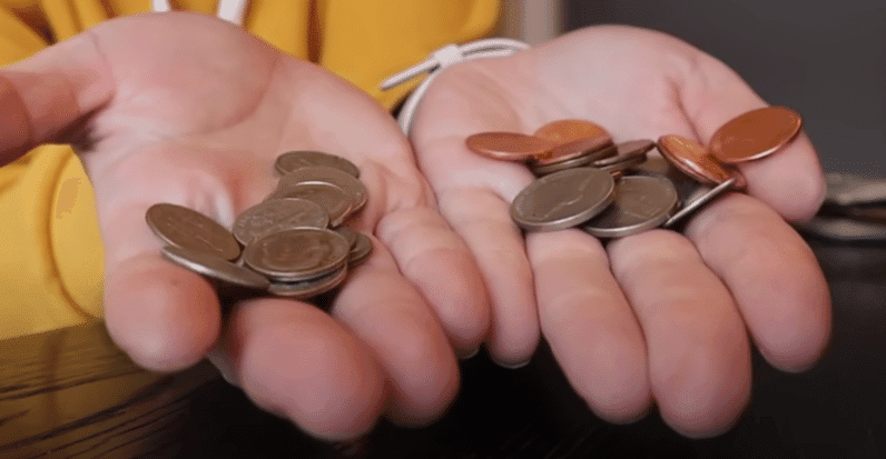 A person holds two coins in their hands, symbolizing strategic budgeting rather than deprivation.