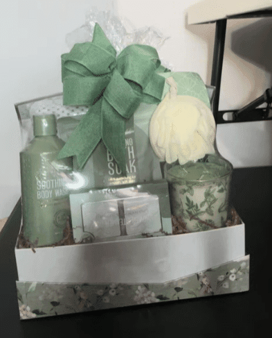A gift basket adorned with a green ribbon and filled with colorful flowers, elegantly arranged for a special occasion.