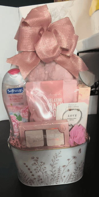 A pink gift basket adorned with a matching pink ribbon, elegantly arranged for a special occasion.