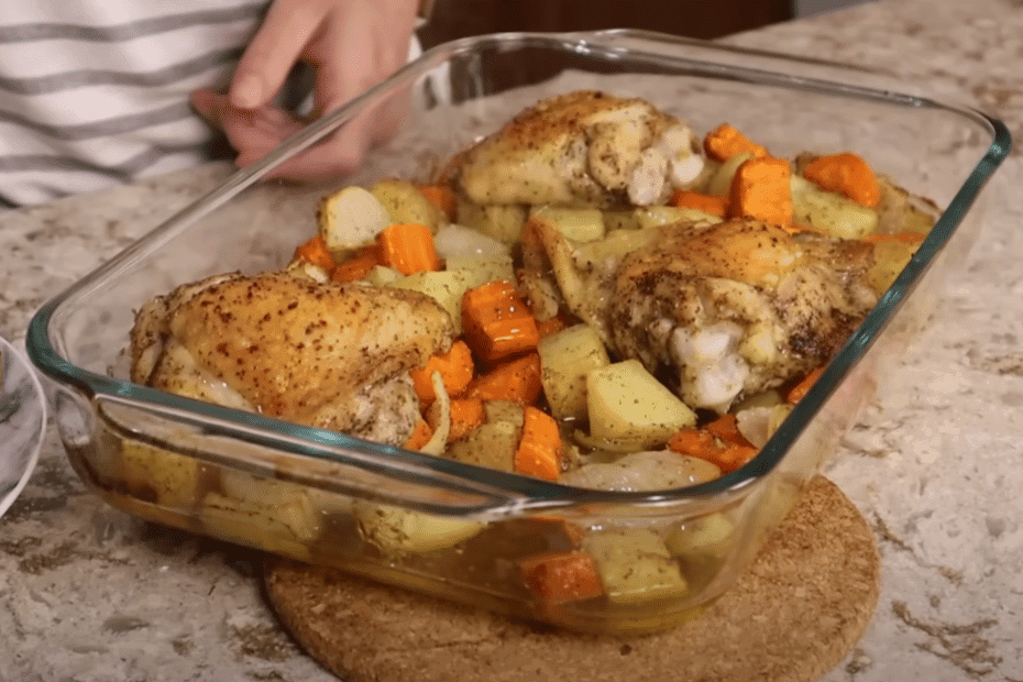A person holds a dish featuring roasted chicken and golden potatoes, ready to be served.