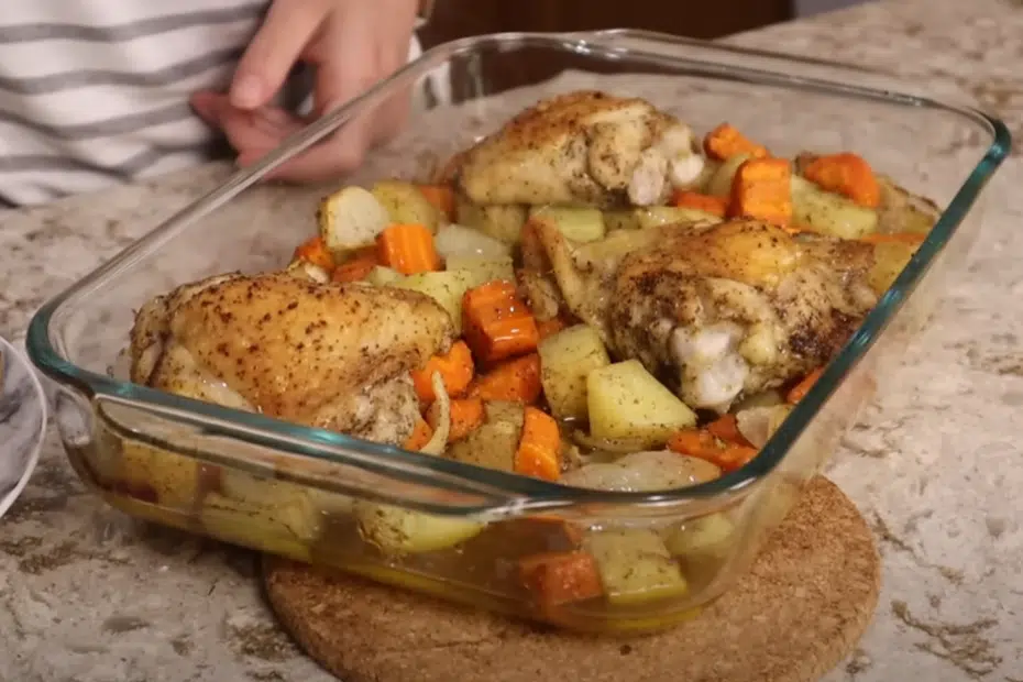 A person holds a dish featuring roasted chicken and golden potatoes, ready to be served.
