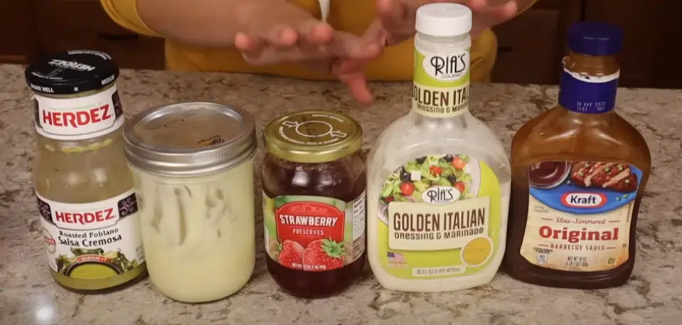 A woman presents a bottle of salad dressing, highlighting the idea of utilizing every ingredient to its fullest potential.