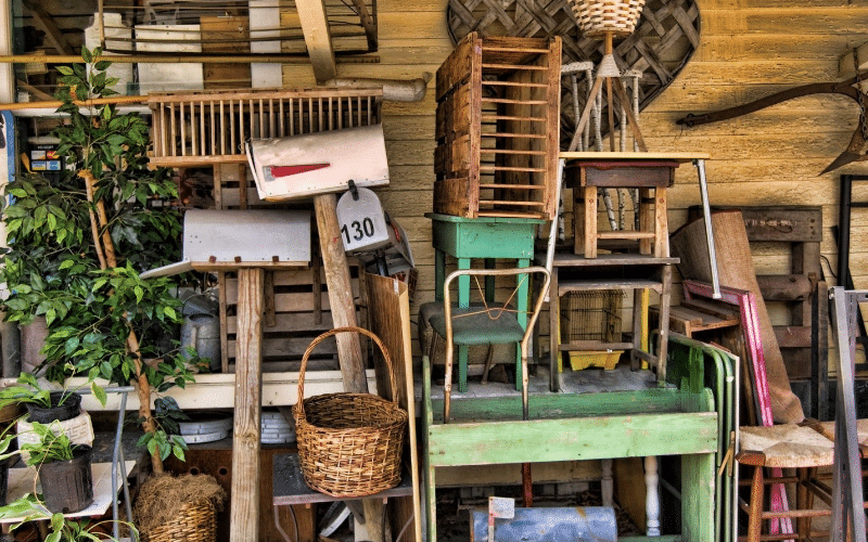 A pile of old furniture and miscellaneous items outside, showcasing potential for farmhouse thrift store makeovers.
