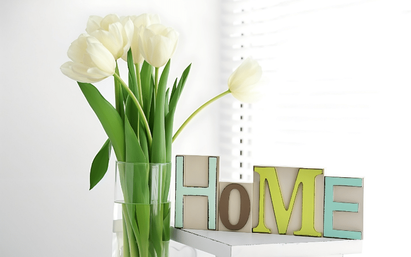 Home decor featuring vibrant tulips alongside wooden letters, promoting a cozy and inviting atmosphere.