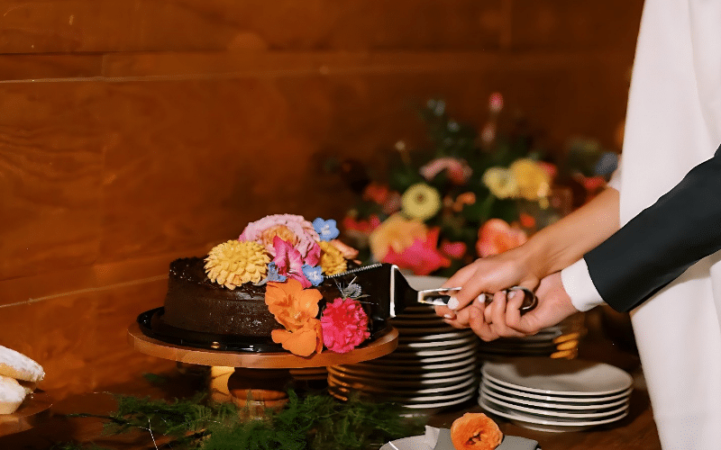 A bride and groom joyfully cutting a chocolate cake, showcasing the popular Costco Wedding Cake Hack.