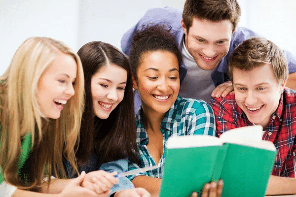 Young people joyfully engage with a book, sharing smiles over "How It Changed My Kids."