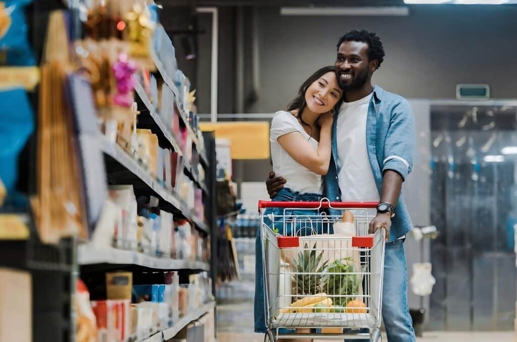 Couple shopping in a supermarket, selecting ingredients for easy meal planning labeled "Lazy-Girl Meals.