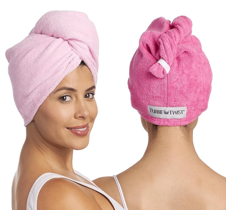 Two women with pink towels on their heads, demonstrating the Hair Turbie towel for drying hair.