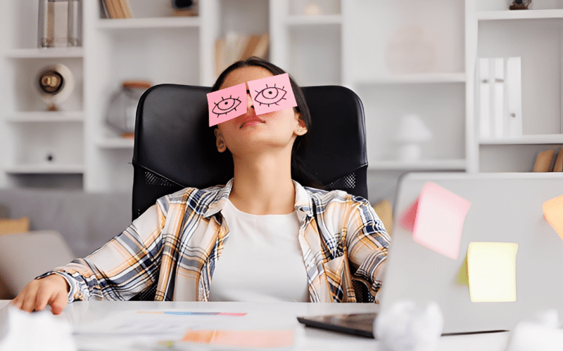 A woman with a smile sits at her desk, embodying the concept of 'Lazy Girl Jobs' in a relaxed work environment.