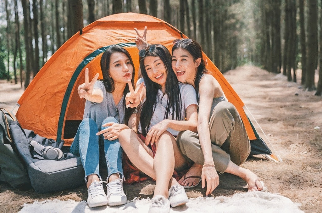 Three women sitting in front of a tent, enjoying an outdoor adventure for an 18th birthday celebration.
