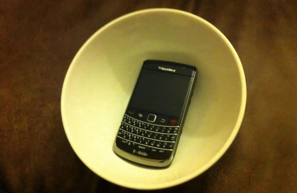 A Blackberry phone resting in a white bowl, illustrating a creative budget speaker arrangement.