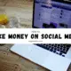 A laptop on a table next to two glasses of juice. The laptop screen displays the text "HOW TO MAKE MONEY ON SOCIAL MEDIA" followed by the website mayawaters.com.
