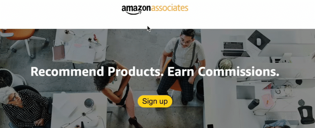 Amazon Associates homepage screenshot showing the slogan “Recommend Products. Earn Commissions.” with a yellow “Sign up” button and people working in an office environment.