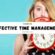A woman holds a clock, symbolizing effective time management with the phrase "Effective Time Management" displayed.