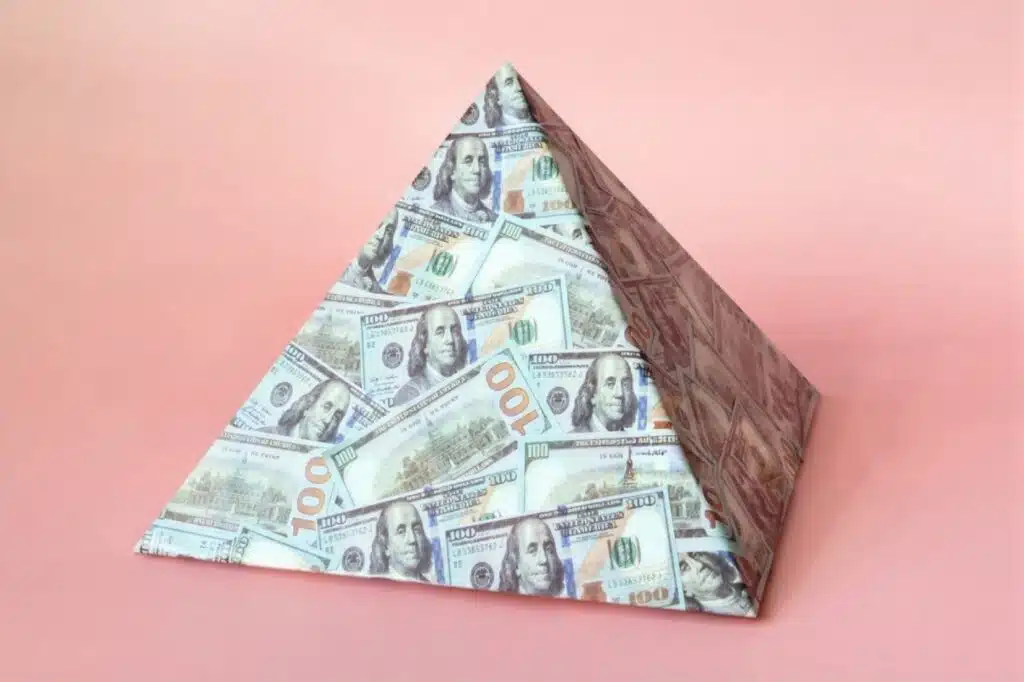 A money pyramid against a pink backdrop, illustrating the cautionary message about MLMs and side hustles to avoid.