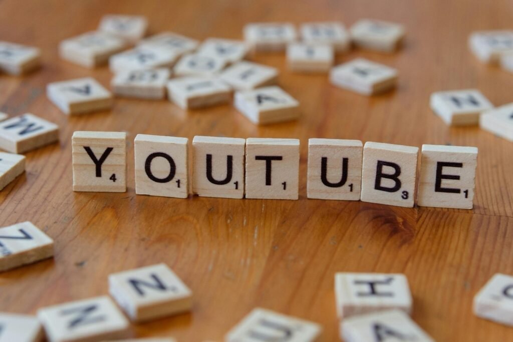 Wooden Scrabble tiles spelling the word YouTube on a table, representing YouTube channel names and video title ideas.