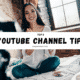 Smiling female YouTuber sitting on her bed with a camera and laptop, banner text saying Top 8 YouTube Channel Tips For Beginners.