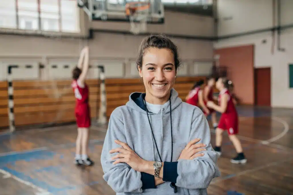 Teen sports coach smiling in a gym, representing guidance and lessons learned from common mistakes in Job Ideas for Teens 13 who are starting to earn money safely and responsibly.