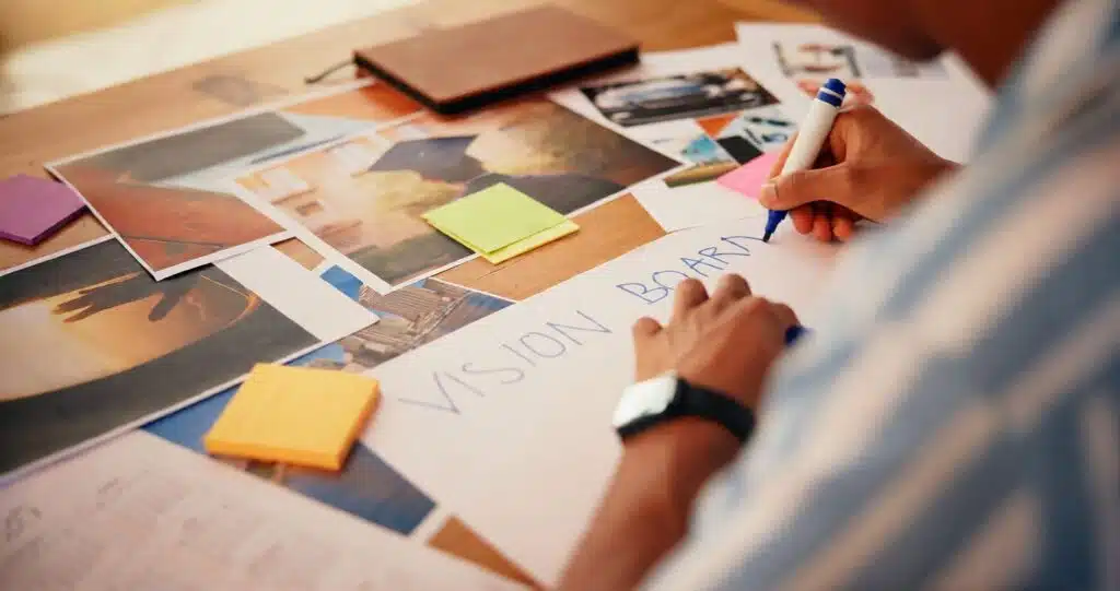 Creating a career vision board at a desk with photos and notes using Job Vision Board Ideas