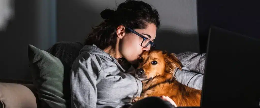 Relaxing at home with a dog during a cozy night in, one of the best No Spend Weekend Ideas for rest, comfort, and saving money.