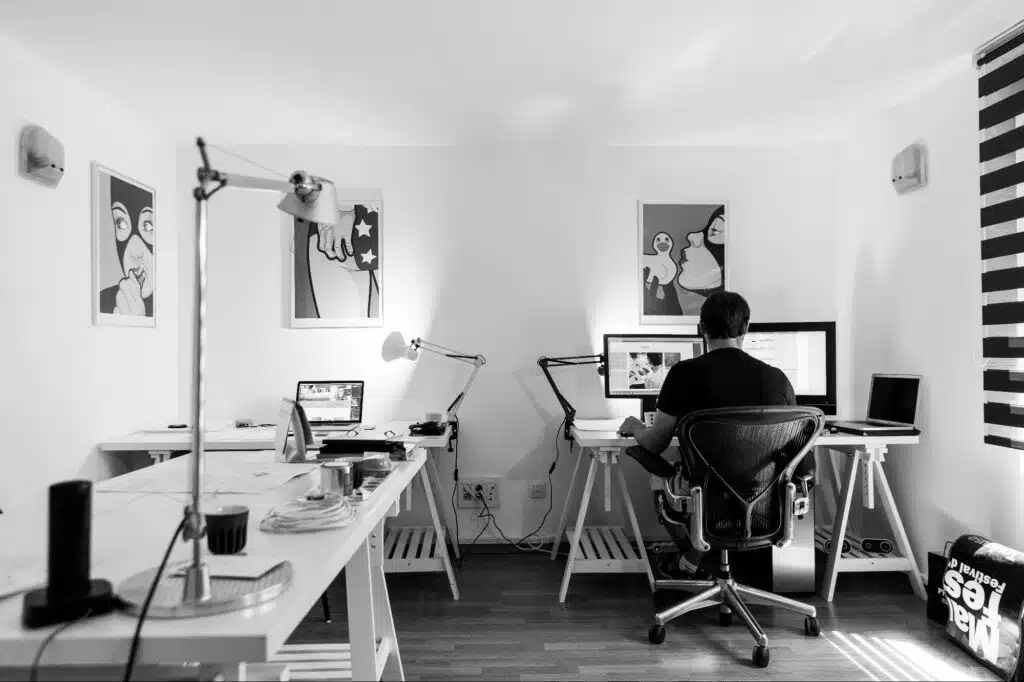 Minimal home office workspace with a small business owner working at a desk, representing branding and creativity for a Small Business Name Ideas List.