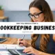 Woman doing bookkeeping work with calculator and financial documents illustrating why you should start a bookkeeping business.