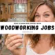 woman holding cash in a woodworking workshop promoting woodworking jobs income.