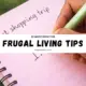 Person writing a shopping list in a notebook illustrating living frugal tips and budgeting strategies to save money.