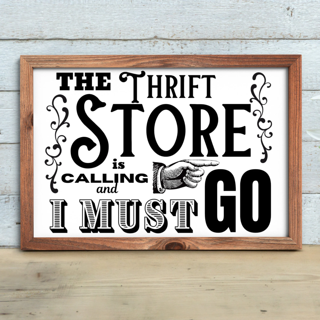 Decorative sign reading "The Thrift Store is Calling and I Must Go" with rustic wooden frame.